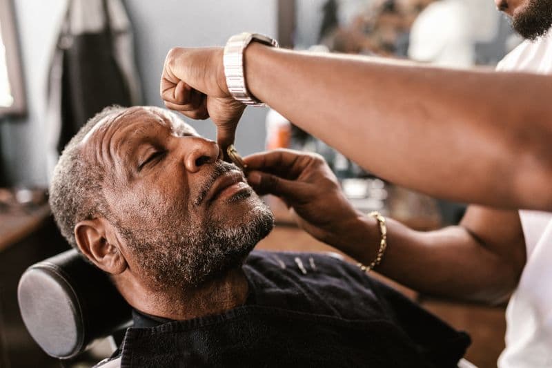 Cliente sendo atendido na cadeira da barbearia