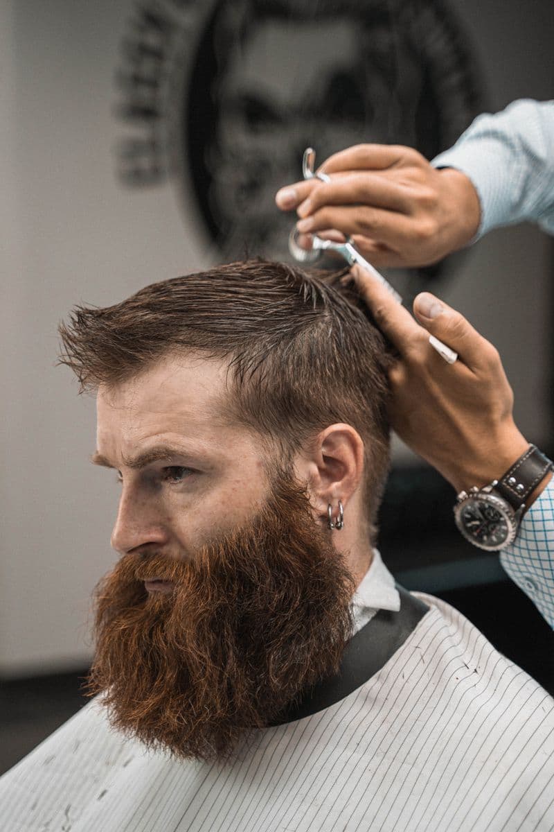 Cliente barbudo com corte finalizado na barbearia